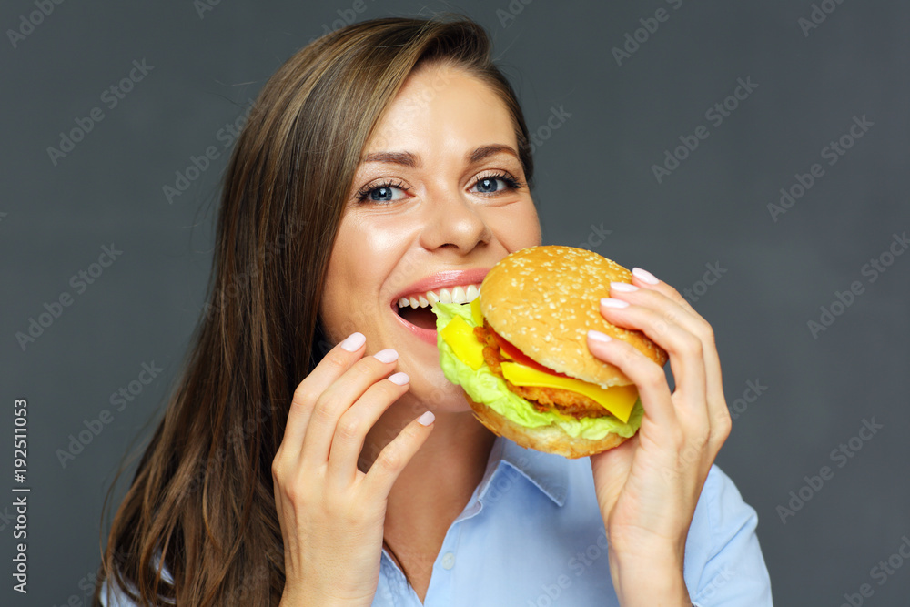 portrait of smiling woman holding big burger.