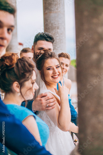Obraz na płótnie Full length portrait of newlywed couple and their friends at the wedding party. Bridesmaids and groomsman with Bride and groom near columns w salonie
