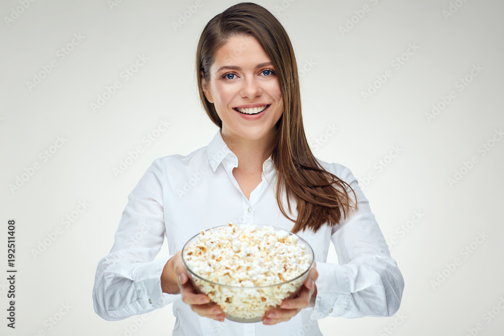 Smiling businesswoman holding big portion of pop corn in glass b Smiling businesswoman holding big portion of pop corn in glass b