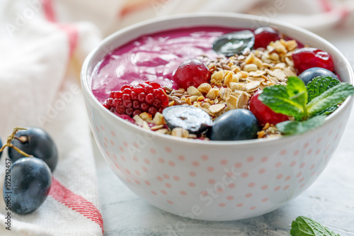 Healthy smoothie bowl with red beets and black grapes.