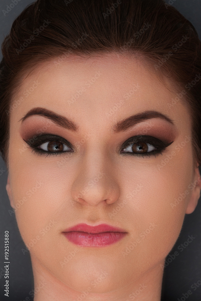 Fototapeta premium Beautiful young model with professional make up, close up shot on the grey background