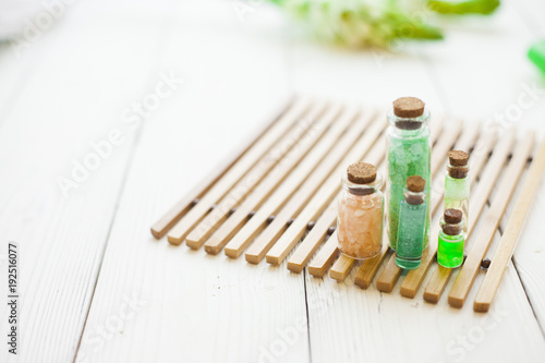 Aromatherapy spa concept with essential oil in glass bottles on wooden bars carpet, closup