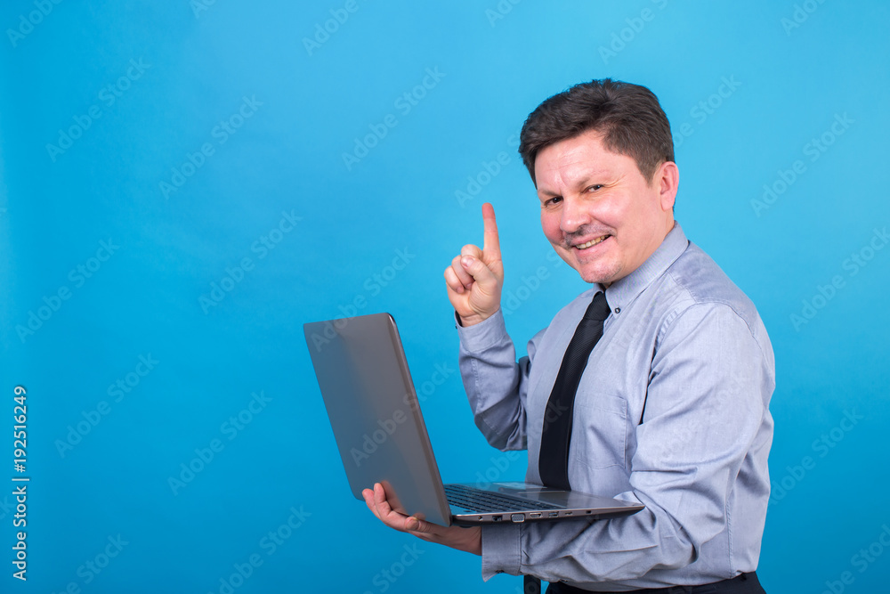 Business man is holding a laptop in his hands and showing his finger up. Business man is holding a laptop in his hands and showing his finger up.