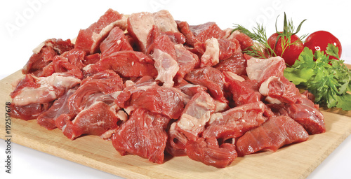 fresh raw red cubed meat chunk on wooden cut board isolated over white background 