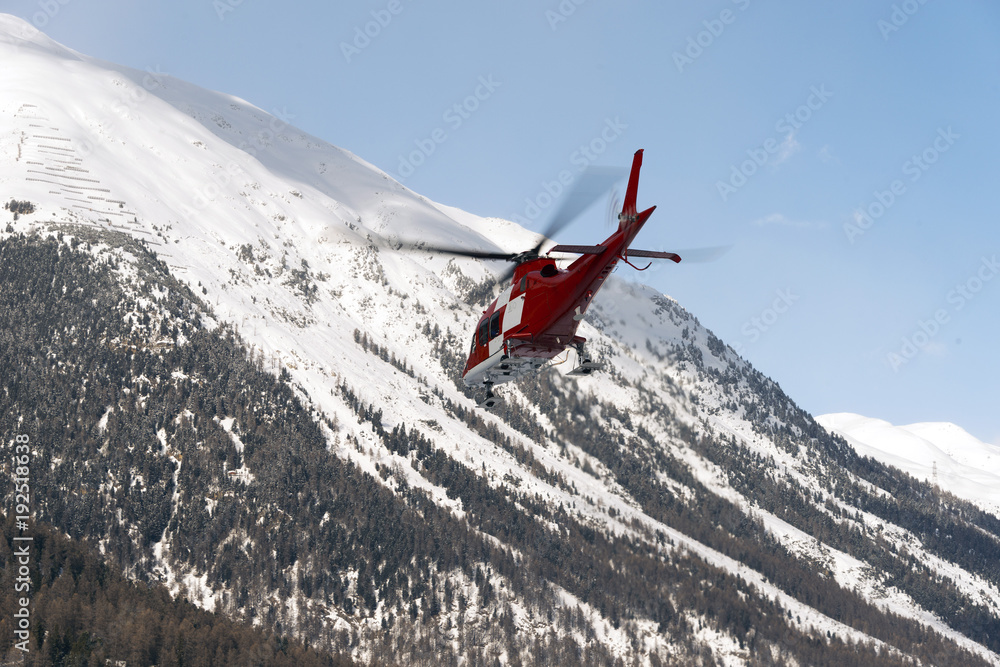 A rescue helicopter in the snowy alps switzerland in winter