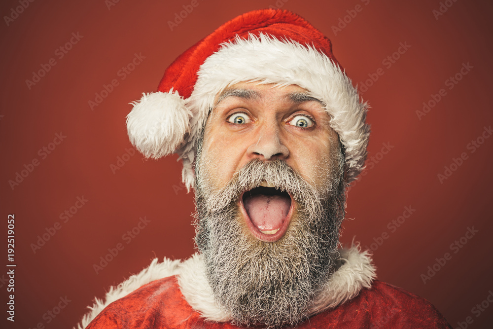 New Year, holidays, Christmas and people concept - cheerful and hilarious Santa Claus man in red traditional outfit isolated on red background. Merry Christmas and Happy New Year! New Year, holidays, Christmas and people concept - cheerful and hilarious Santa Claus man in red traditional outfit isolated on red background. Merry Christmas and Happy New Year!