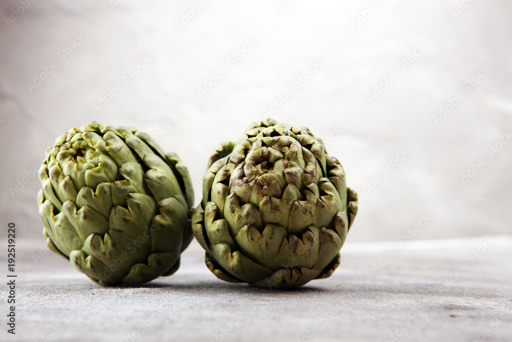 Fototapeta premium artichokes on grey background. fresh organic artichoke flower.