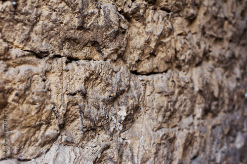 Close up Textured background of a wall of medieval stone masonry. The wall is sloppy built of mountain stones. Medieval style