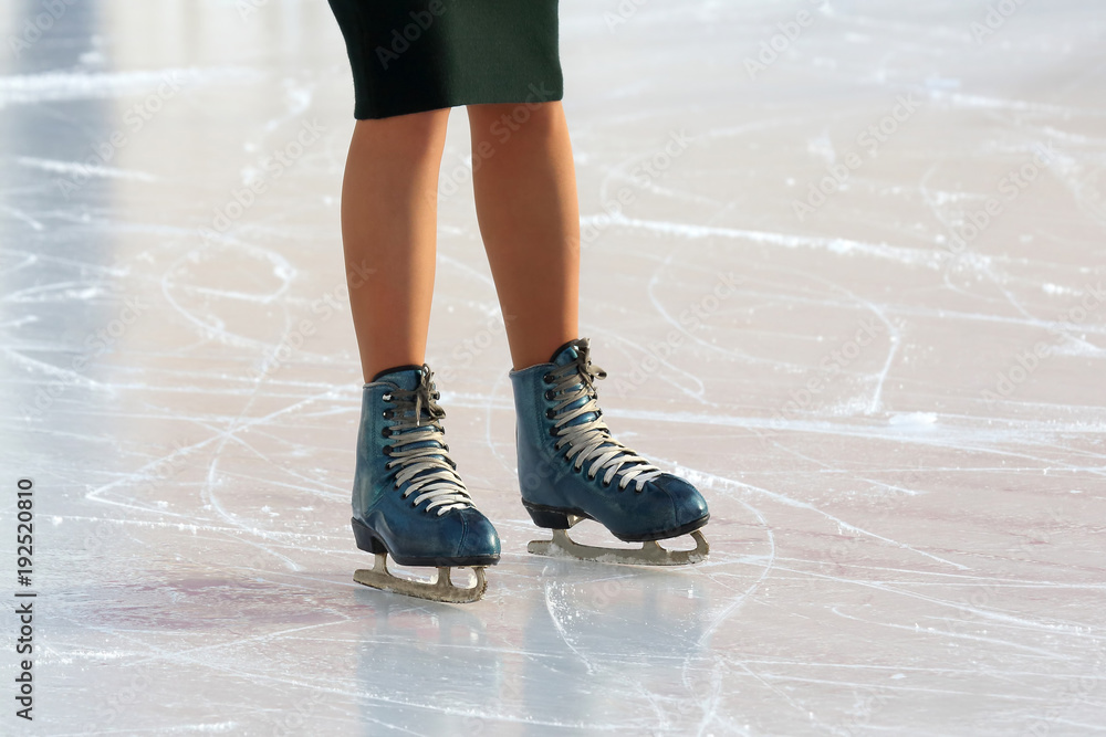 feet on the skates of a person rolling on the ice rink feet on the skates of a person rolling on the ice rink