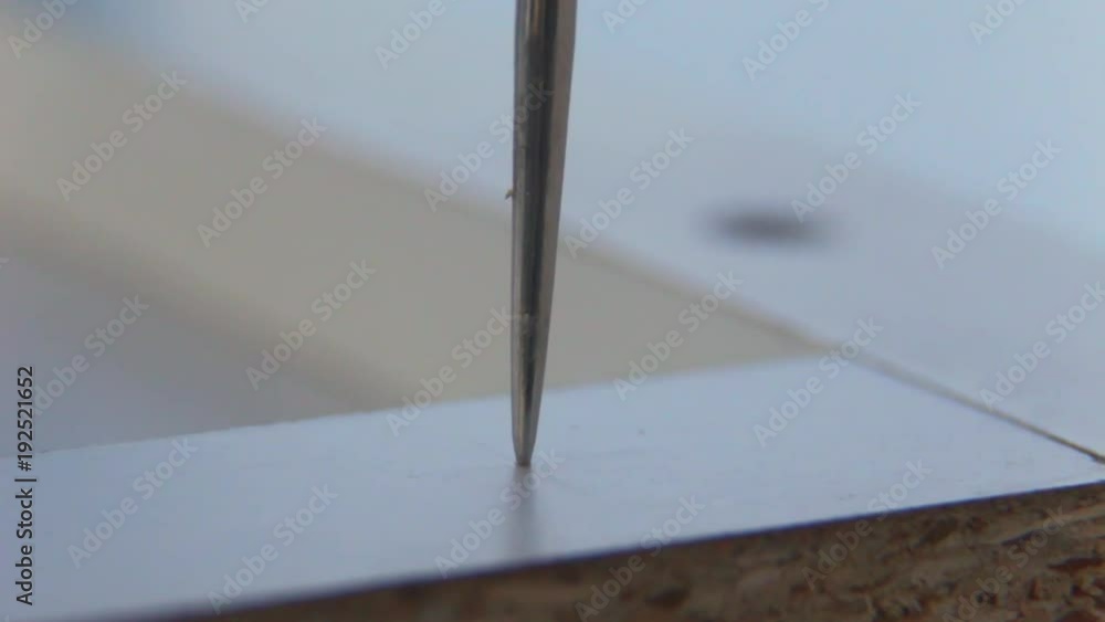Macro. Close-up. The furniture master pierces an aperture in a white chipboard. Macro. Close-up. The furniture master pierces an aperture in a white chipboard.