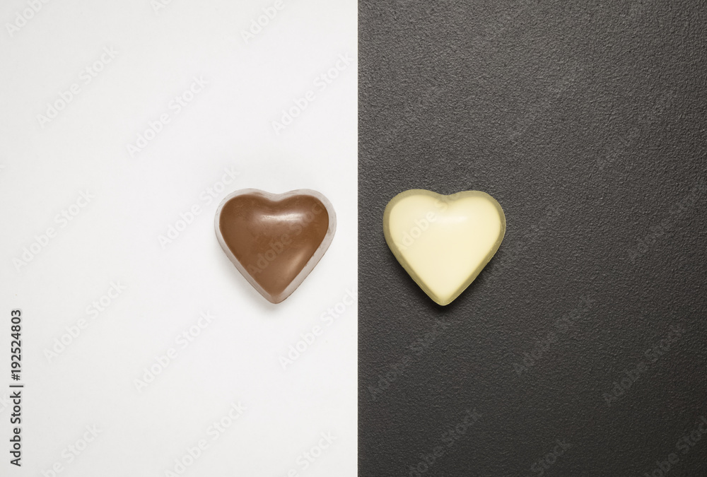 Obraz premium Top view of heart shaped chocolate bars on black and white