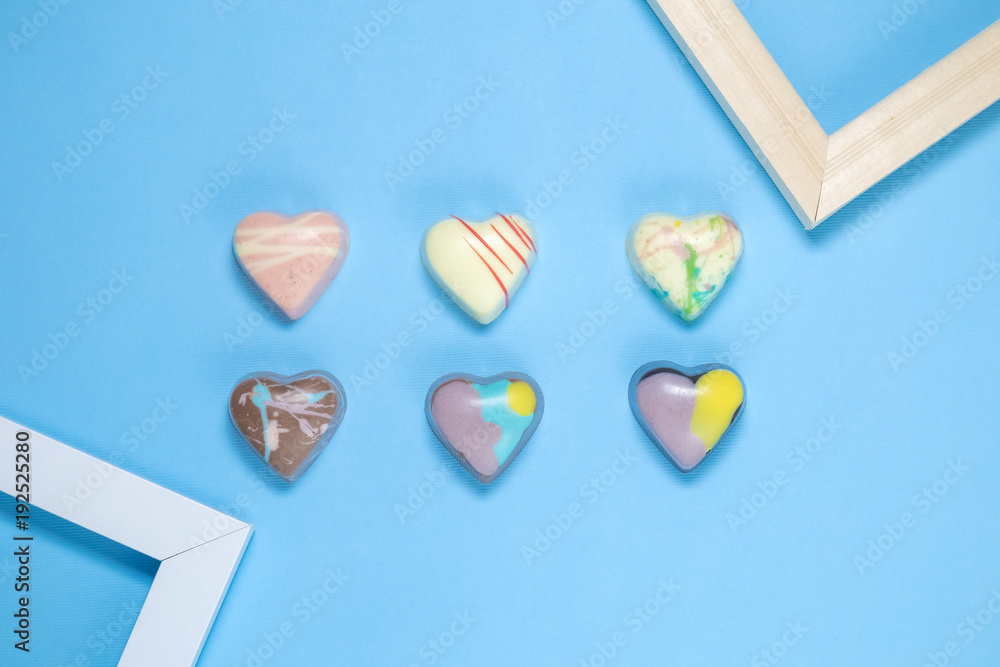 Six Belgian chocolate hearts with frames on blue background Six Belgian chocolate hearts with frames on blue background