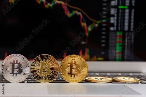  golden bitcoin on keyboard with chart on monitor