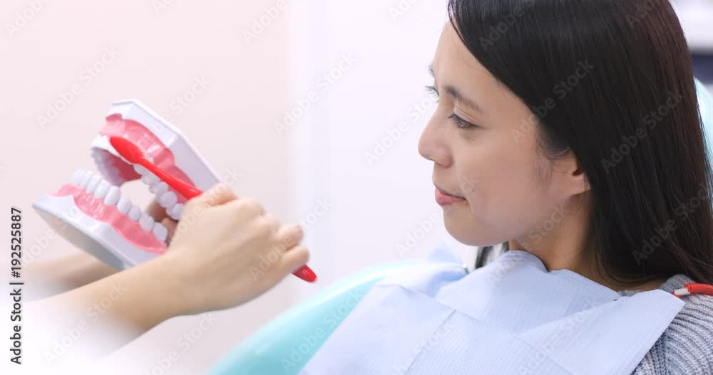 Dentist teaching patient how to brush teeth Dentist teaching patient how to brush teeth