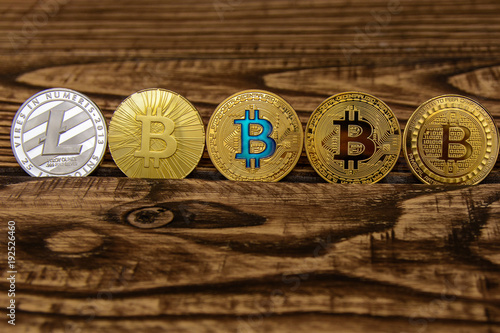  golden bitcoin stand in a row on wooden table