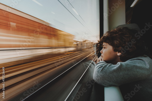 Close-up of a young Boy leaning on a window sill Looking Through a Train Window photo
