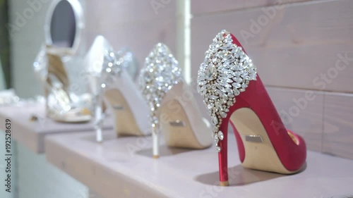 Beautiful luxury pair of high heels white bridal shoes lace sandals standing in wedding shop and waiting for bride on her wedding day. White wedding shoes for women. Happy woman with new high heels. 