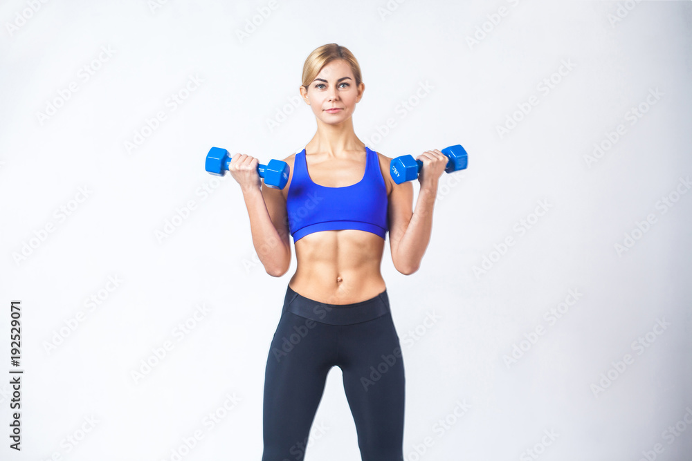 Portrait of woman with perfect body, holding two blue dumbbells Portrait of woman with perfect body, holding two blue dumbbells