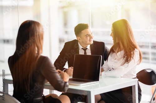 Canvastavla Young love couple sitting at a desk in the office of their agent or adviser discussing an investment presentation