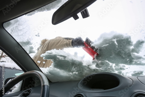 Cleaning snowy car in winter photo