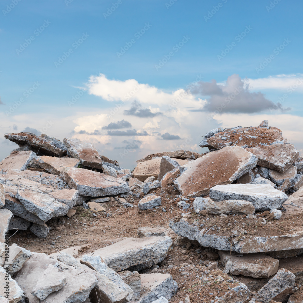 Stack of concrete debris with sky clouds.