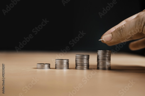 Business Growth concept, Man's hand put money coins to stack of coins.