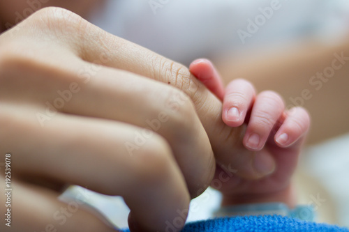 Close-up of a newborns finger touching mothers hand.Selective focus.