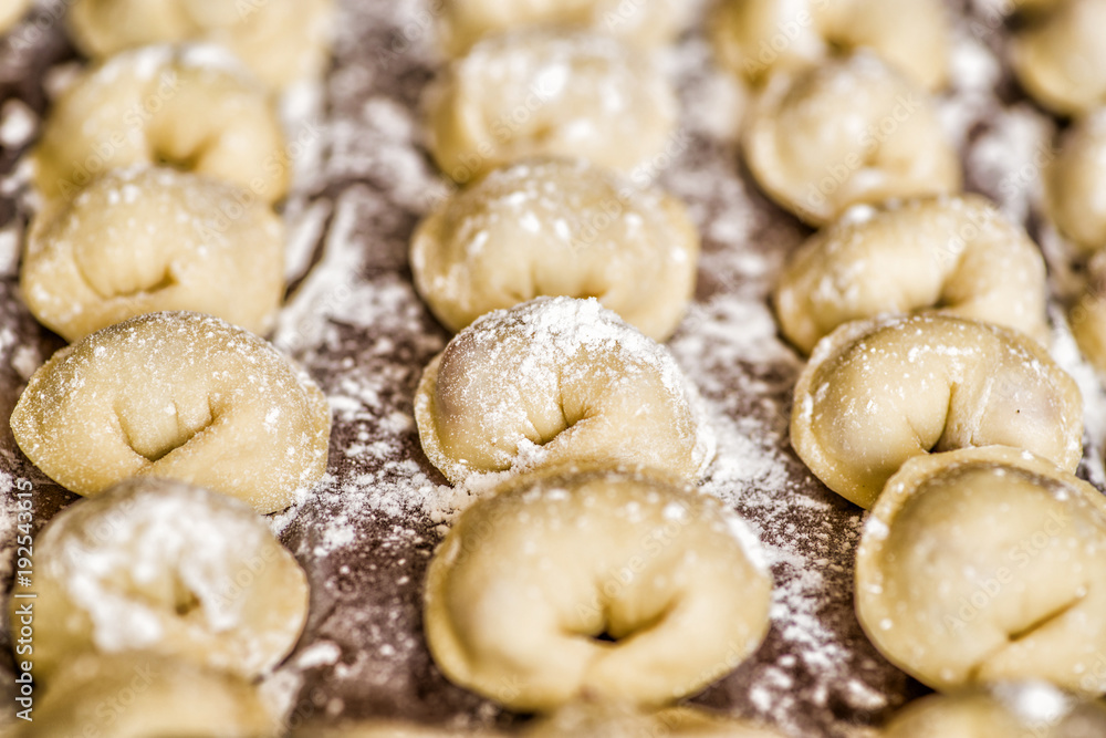 dumplings in raws on a wooden table covered with flour dumplings in raws on a wooden table covered with flour