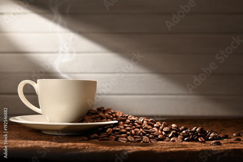 Cup of coffee with smoke and coffee beans on wooden background, This image with no smoke is available