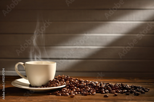Cup of coffee with smoke and coffee beans on wooden background, This image with no smoke is available
