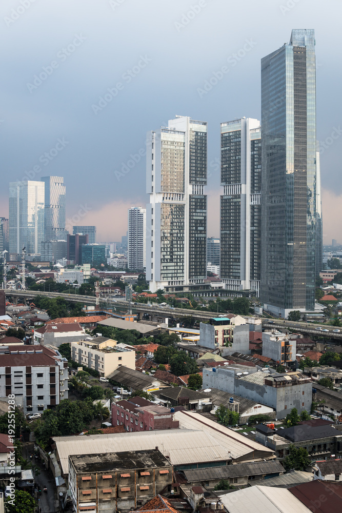 Fototapeta premium Widok z lotu ptaka na dzielnicę mieszkaniową, mieszanie niskich domów i luksusowych wież mieszkalnych w Dżakarcie