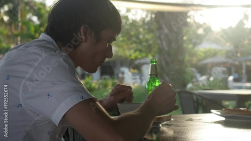 Young man eating coconut soup in beach cafe.3840x2160