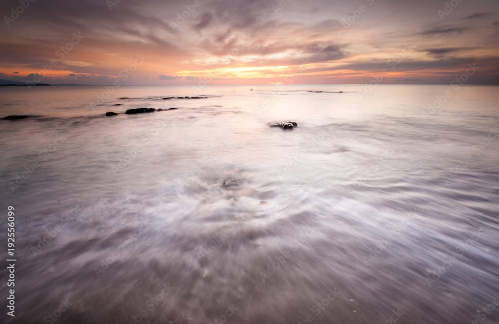 Obraz premium long expose sunset seascape with waves trails. image contain soft focus due to long expose.