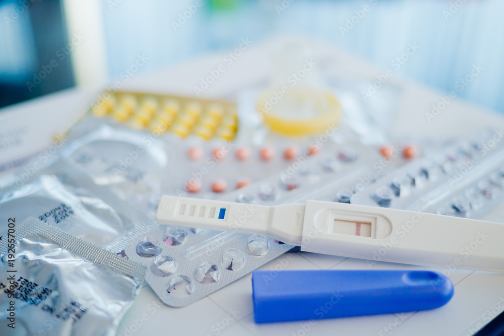 condom with contraceptive and pregnancy test on calendar, Birth control pill, safe sex, healthcare concept
