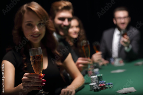 fashion woman with glasses of wine,sitting at a table in a casino