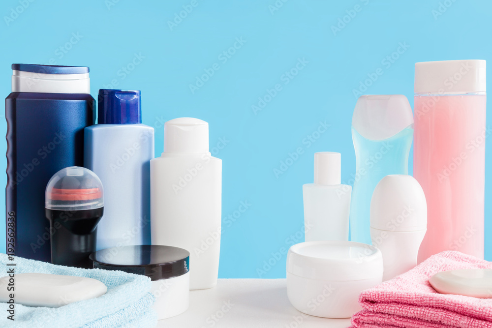 Different, colorful beauty toiletries, cream jars, soaps and towels on the  blue background. Body relax and care products for women and men. Empty  place for text or a logo. Front view. Stock