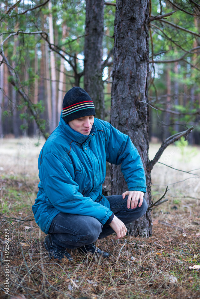 A rural guy posing in a pine forest in the autumn time. A rural guy posing in a pine forest in the autumn time.