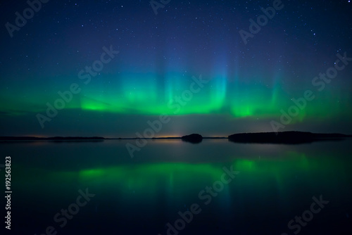Fototapeta Naklejka Na Ścianę i Meble -  Northern lights dancing over calm lake. Farnebofjarden national park in Sweden