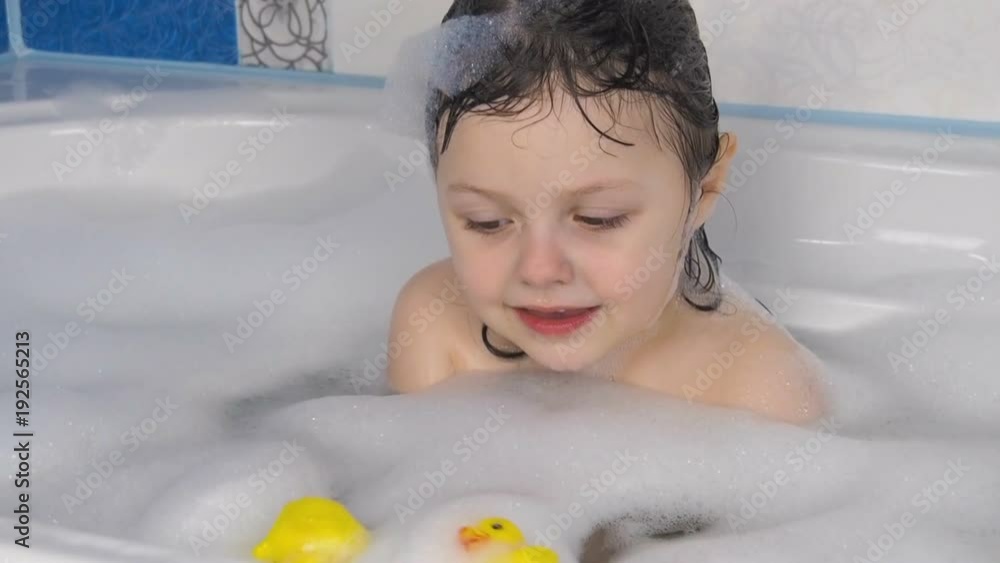 The child is played in the bathroom. Beautiful little girl with toys in the bathroom. The child is played in the bathroom. Beautiful little girl with toys in the bathroom.