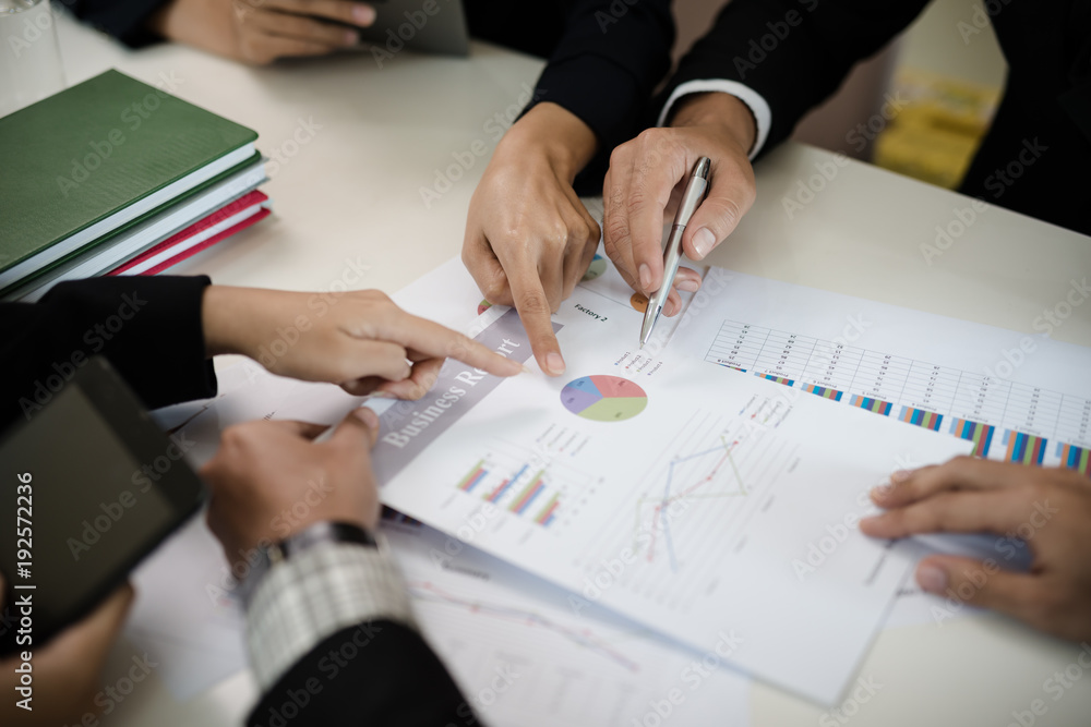A group of business men and women are meeting see report on business A group of business men and women are meeting see report on business
