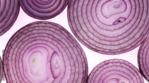 Sliced red onion rotation on white background in 4K. Closeup top view.
