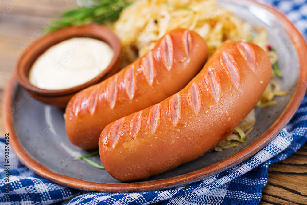 Plate of sausages and sauerkraut on wooden table. Traditional Oktoberfest menu Plate of sausages and sauerkraut on wooden table. Traditional Oktoberfest menu