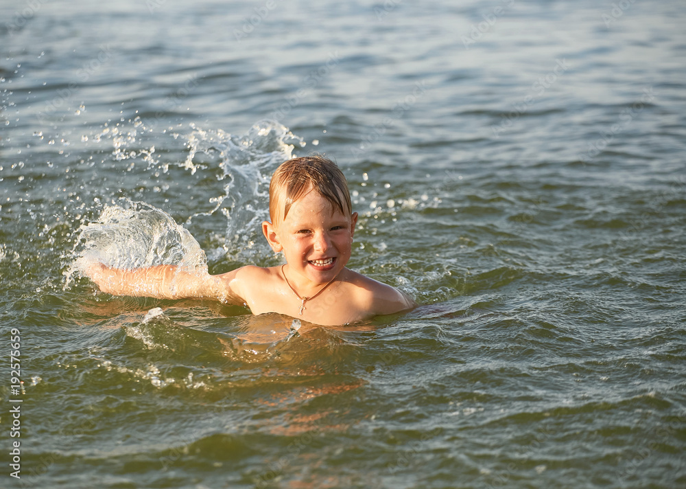 The boy is swimming in the sea.