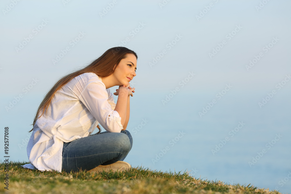 Relaxed woman thinking and looking away on the beach Relaxed woman thinking and looking away on the beach