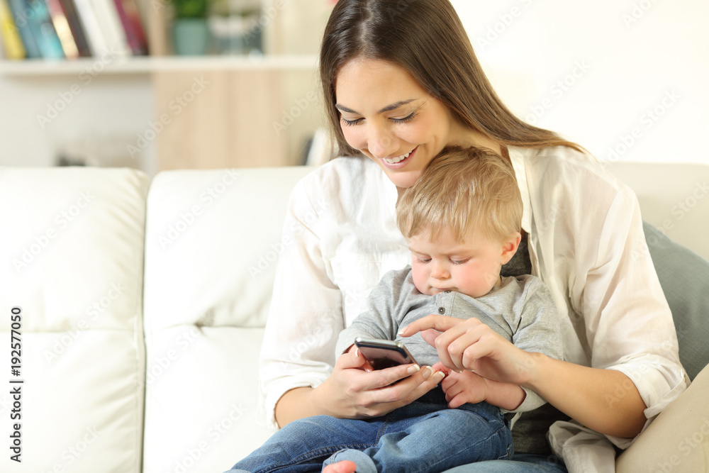 Mother showing smart phone content to his baby son Mother showing smart phone content to his baby son