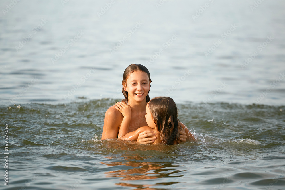 Girls sisters have fun bathing in the sea Girls sisters have fun bathing in the sea