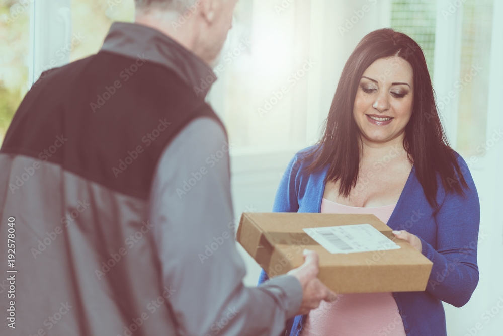 Woman receiving package from delivery man Woman receiving package from delivery man