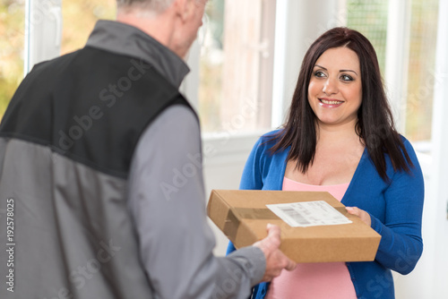 Woman receiving package from delivery man © thodonal