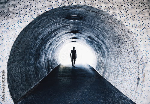 Man walking in tiled tunnel photo