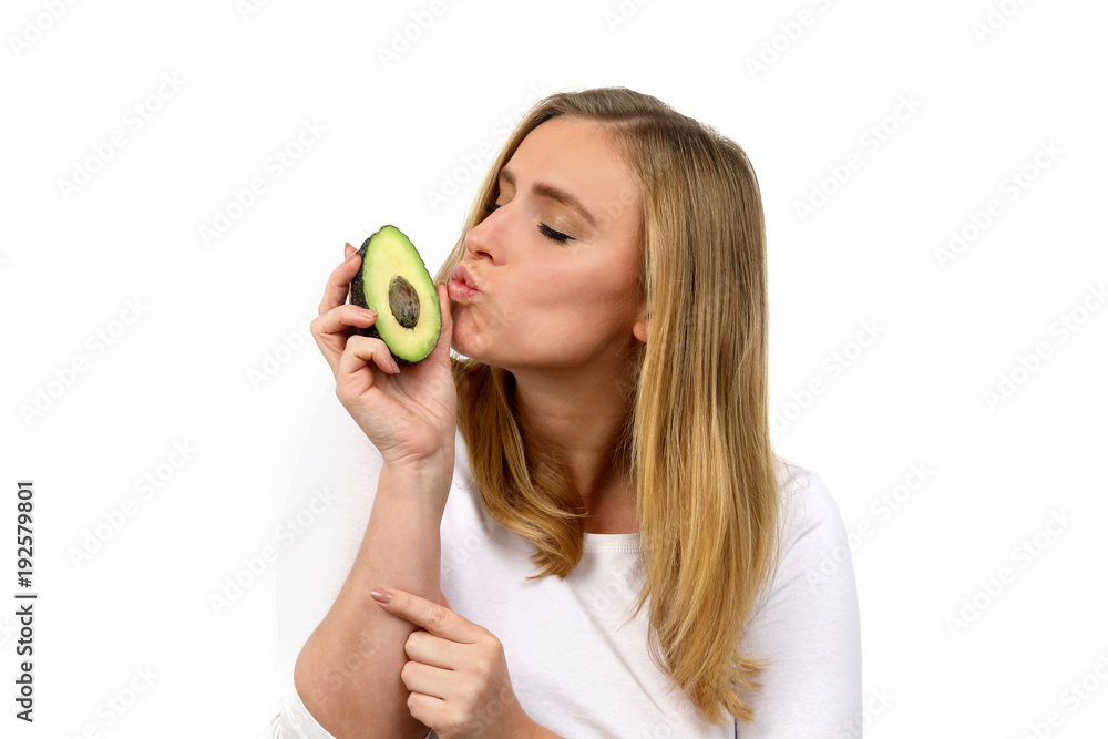 Hübsche blonde Frau küsst eine Avocado Hübsche blonde Frau küsst eine Avocado